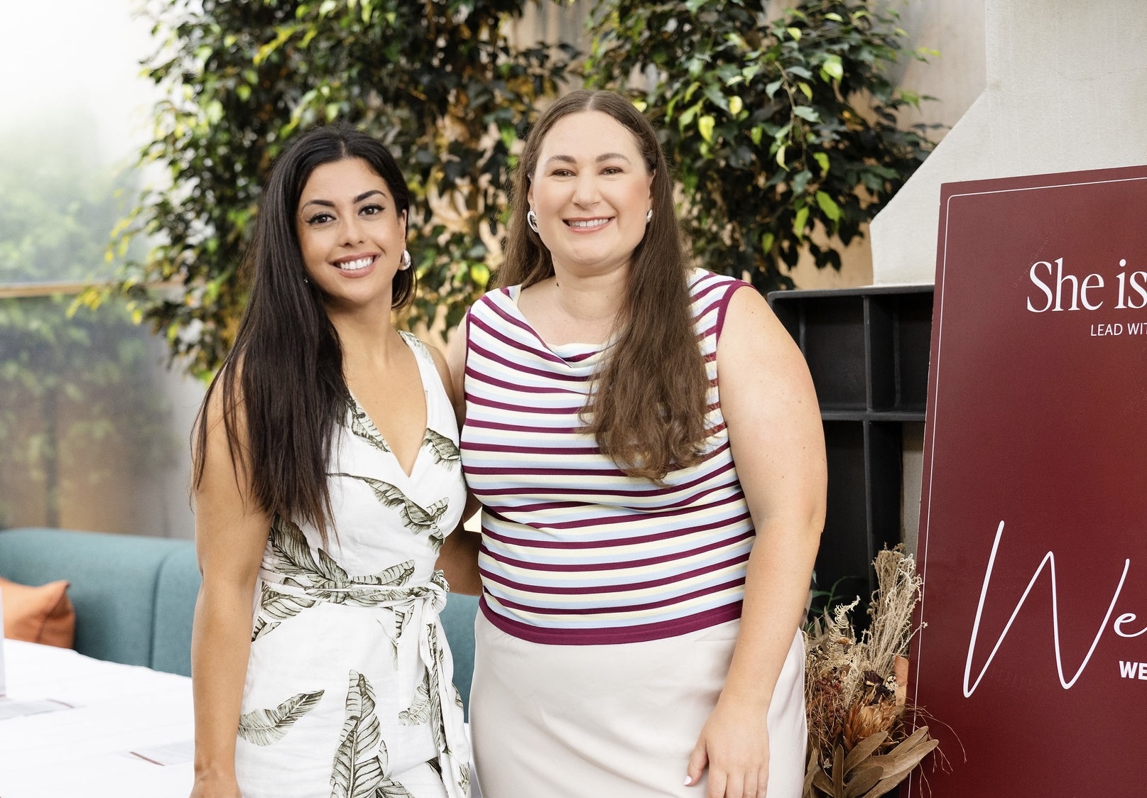 Two guests beside the She Is Unleashed welcome sign