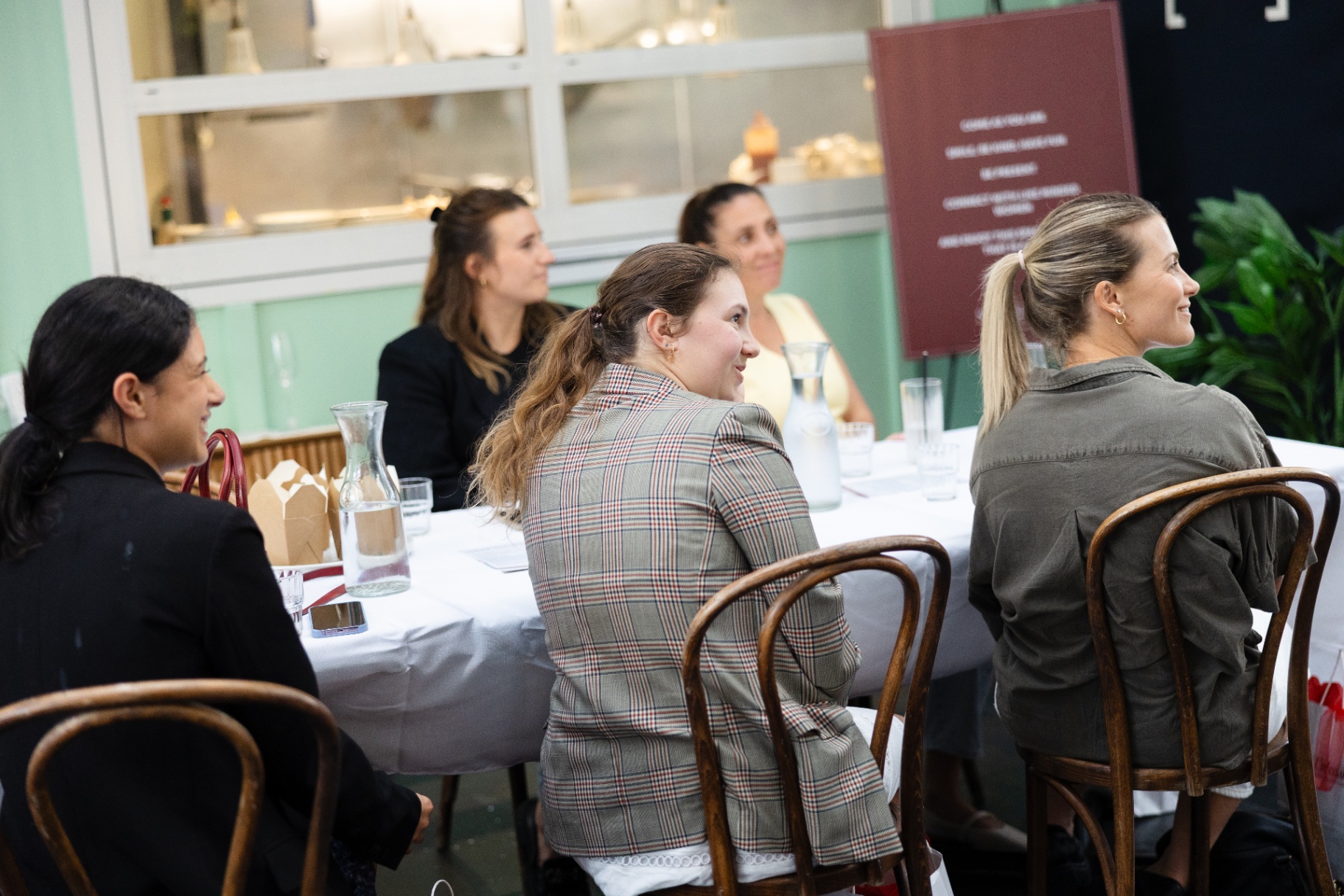 Guests smiling around the table during the Auckland session