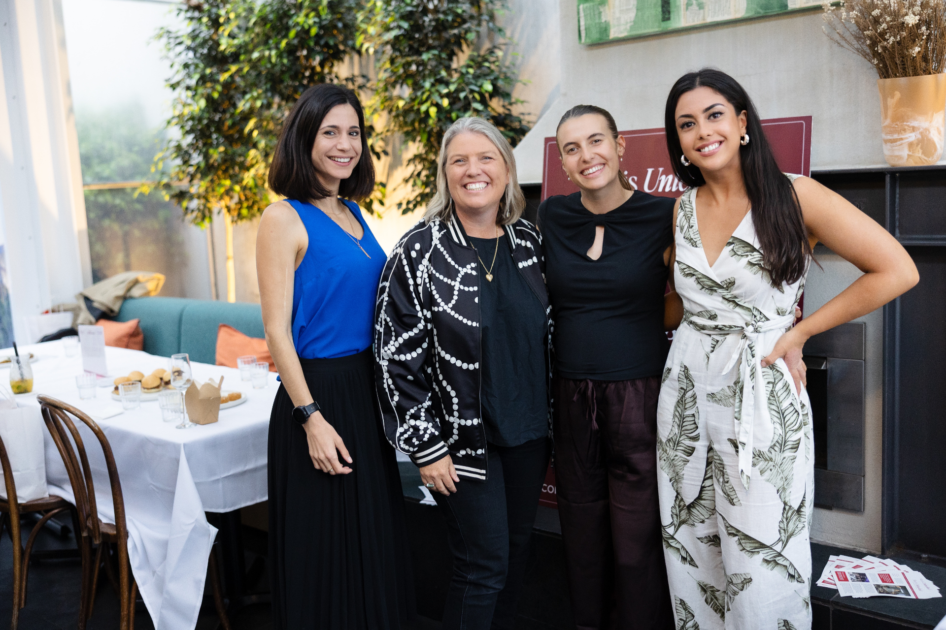 Four women smiling together at Meadow Restaurant