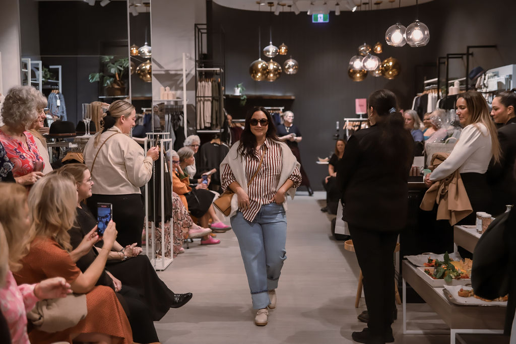 A model walking the runway in stripes and denim