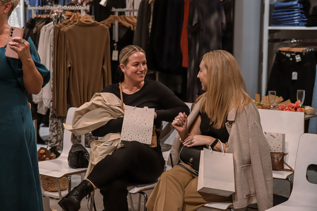 Two guests laughing together with their goodie bags