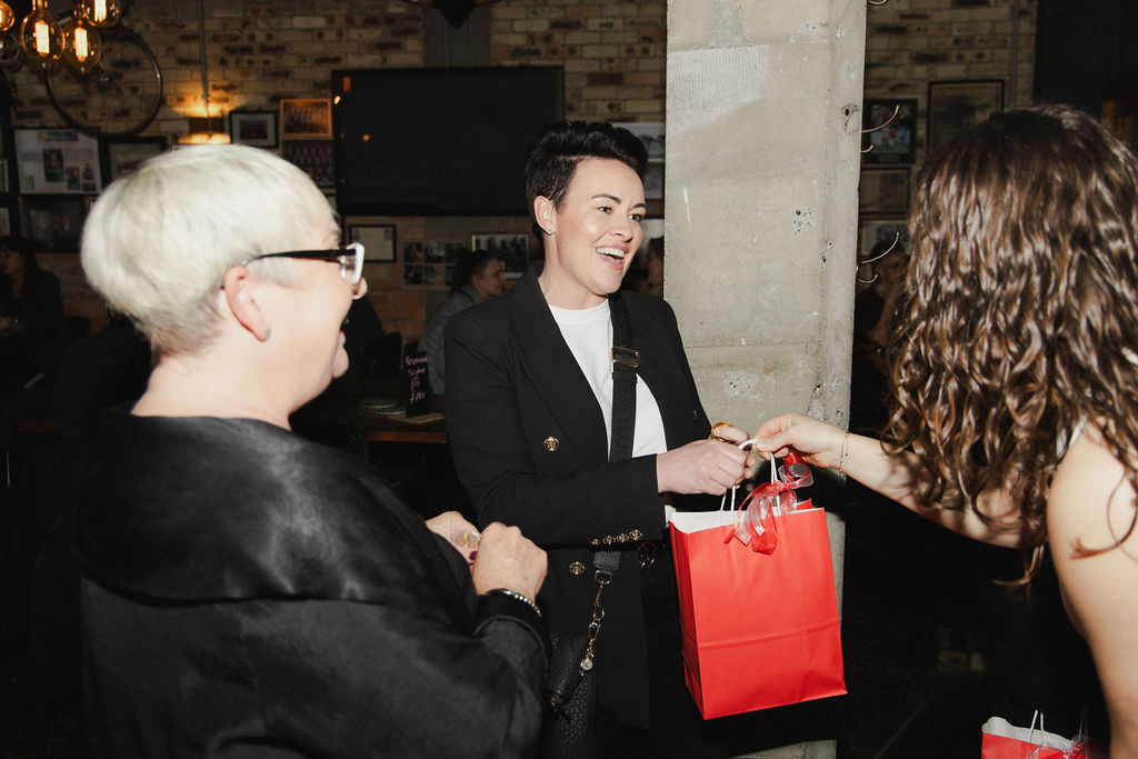 A She Is Unleashed goodie bag being handed to a guest
