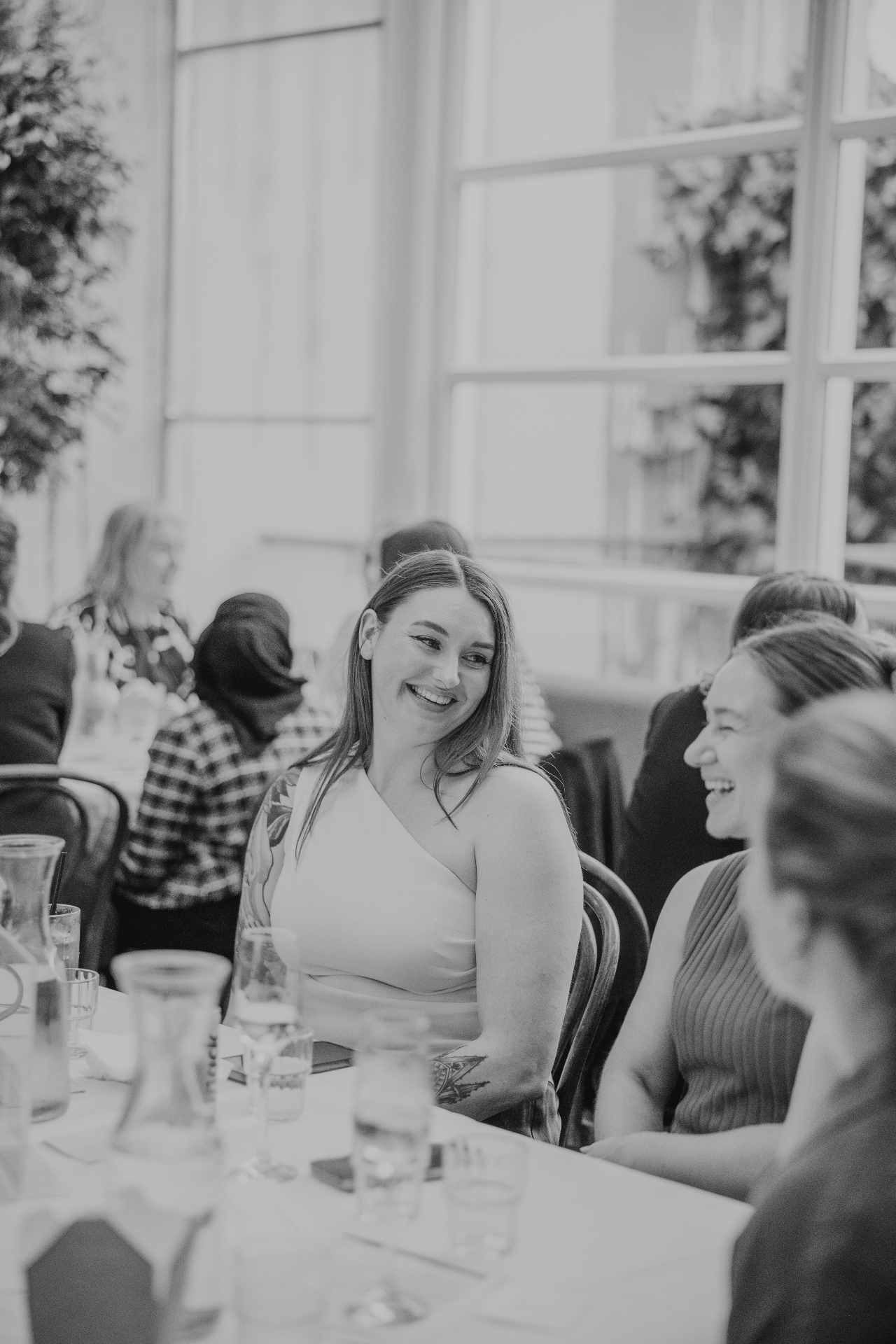 A guest smiling across the table during the group conversation