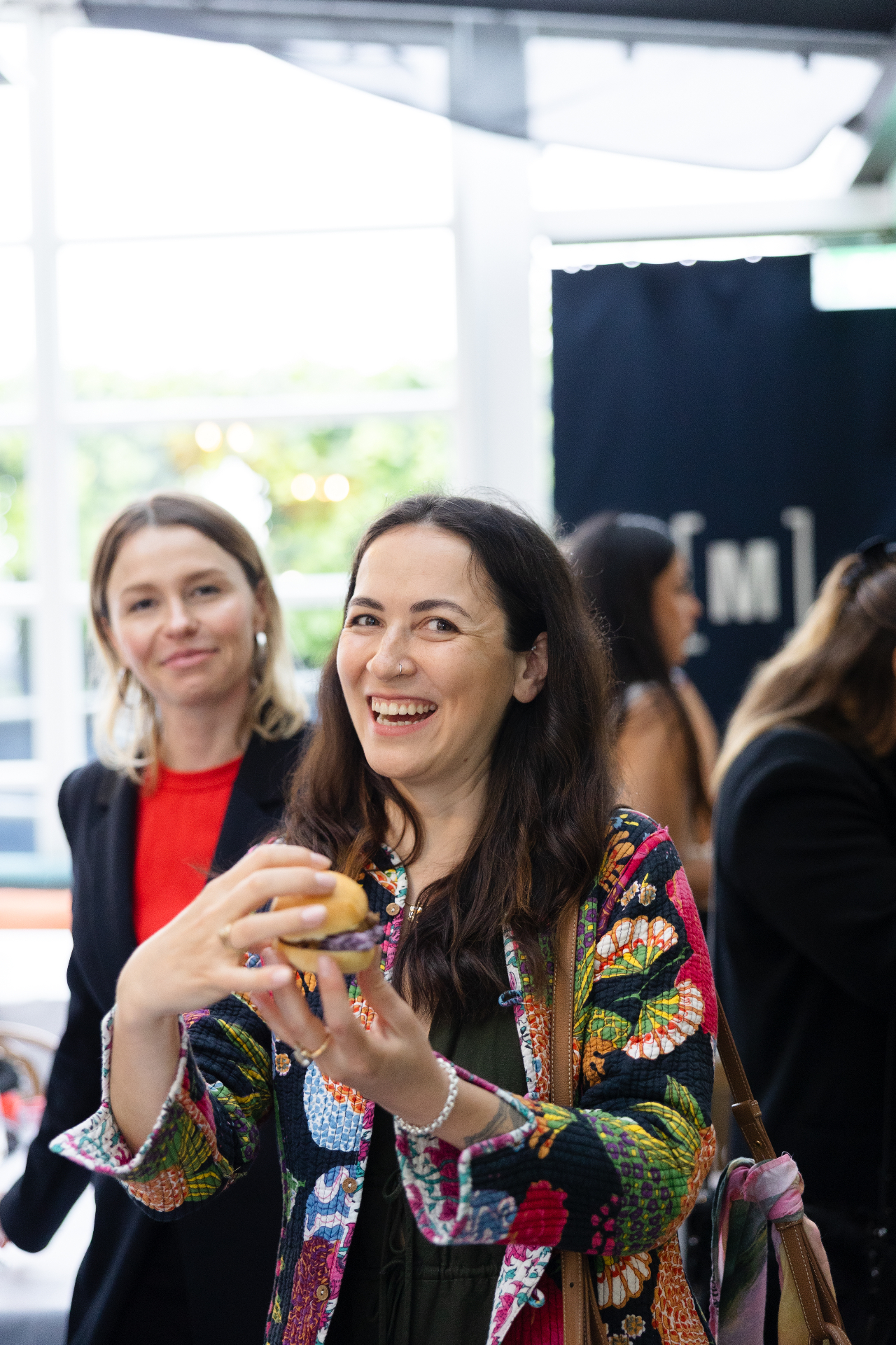 A guest laughing while enjoying the canapes