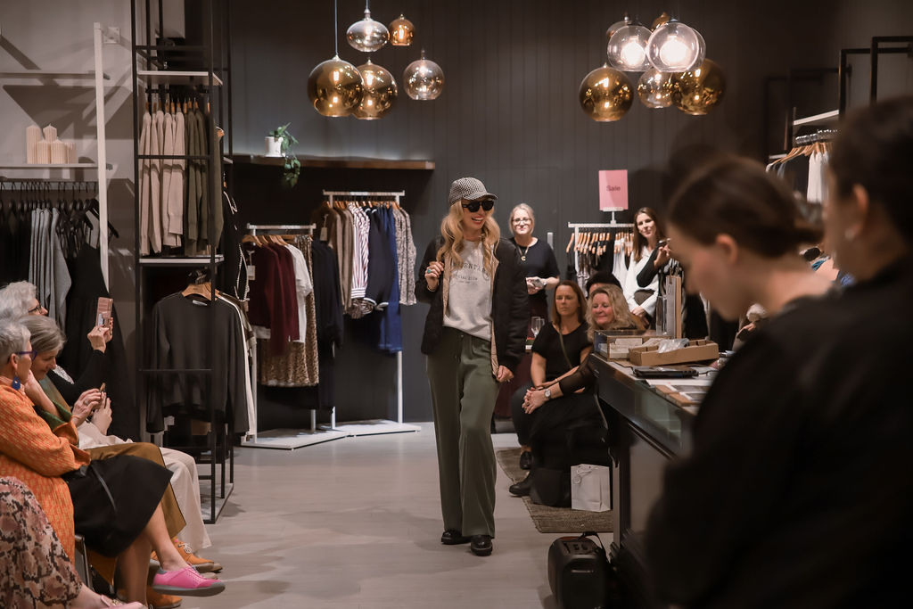 A model on the runway in a cap and wide leg trousers