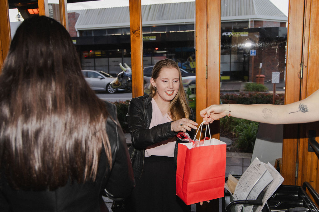 A guest receiving a She Is Unleashed goodie bag at The Redoubt in Morrinsville