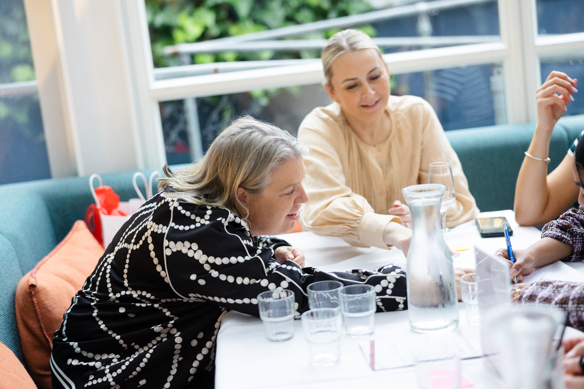 Guests leaning in over notes during a collaborative discussion