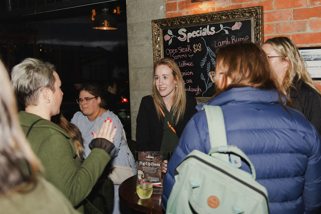 A guest speaking to the group beside the Pop Up Event sign