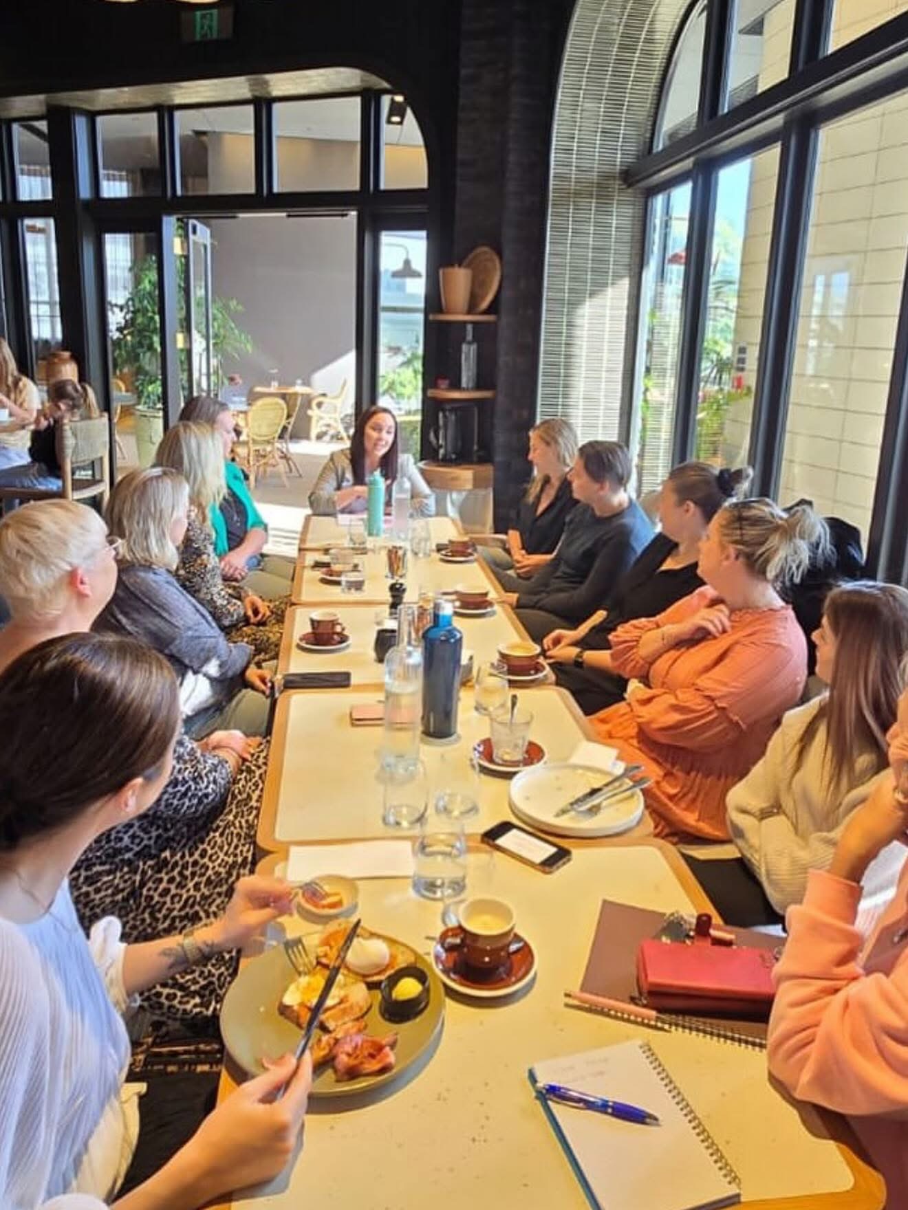 Women in business gathered around a table at a She Is Unleashed weekly group