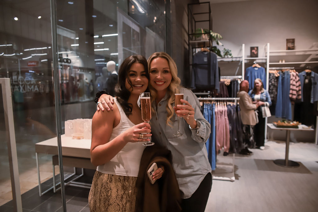 Two guests toasting with champagne in store